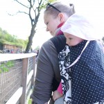 Baby auf dem Rücken in Halbschnallentrage